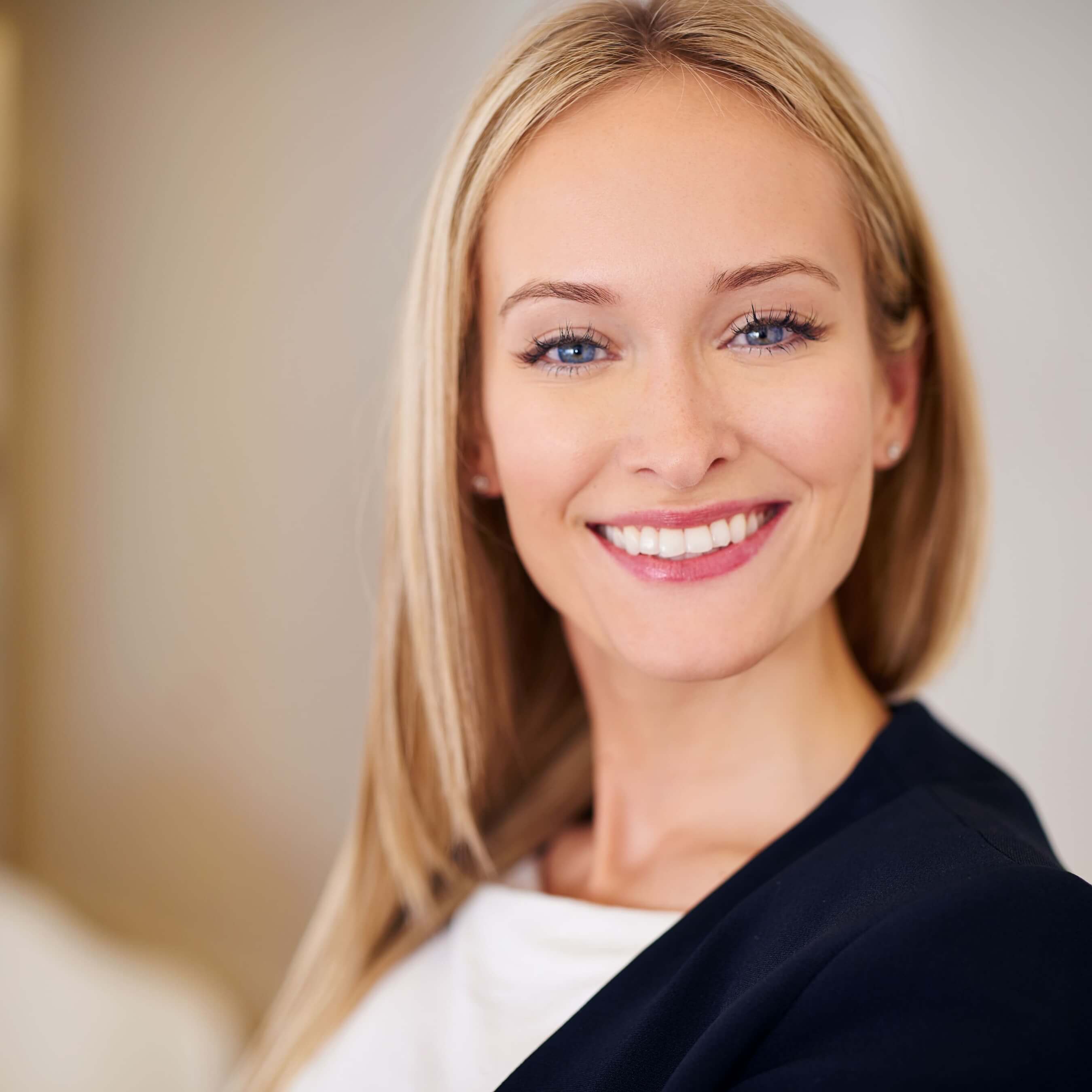 Smiling woman with blonde hair in a professional portrait setting