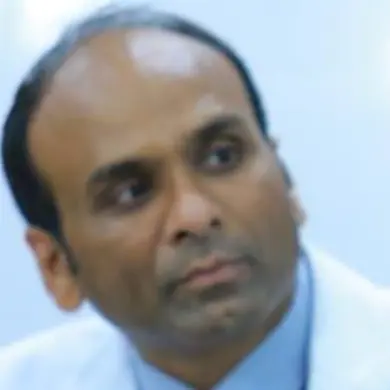 A close-up portrait of Deepak, a man with a bald head, looking thoughtfully to the side