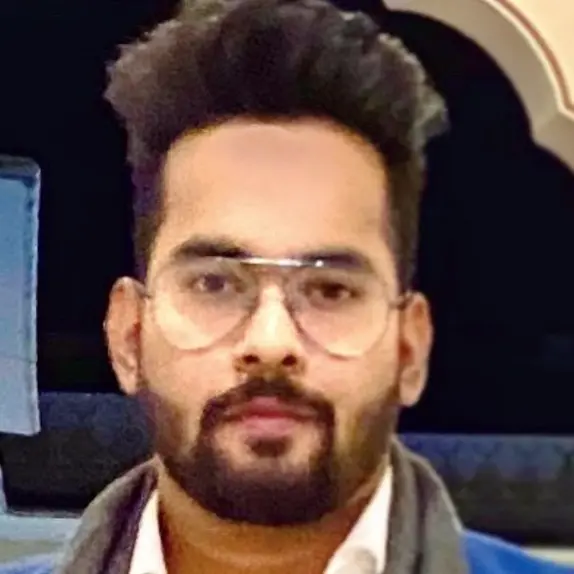 Portrait of Gaurav wearing glasses with a beard in an indoor setting