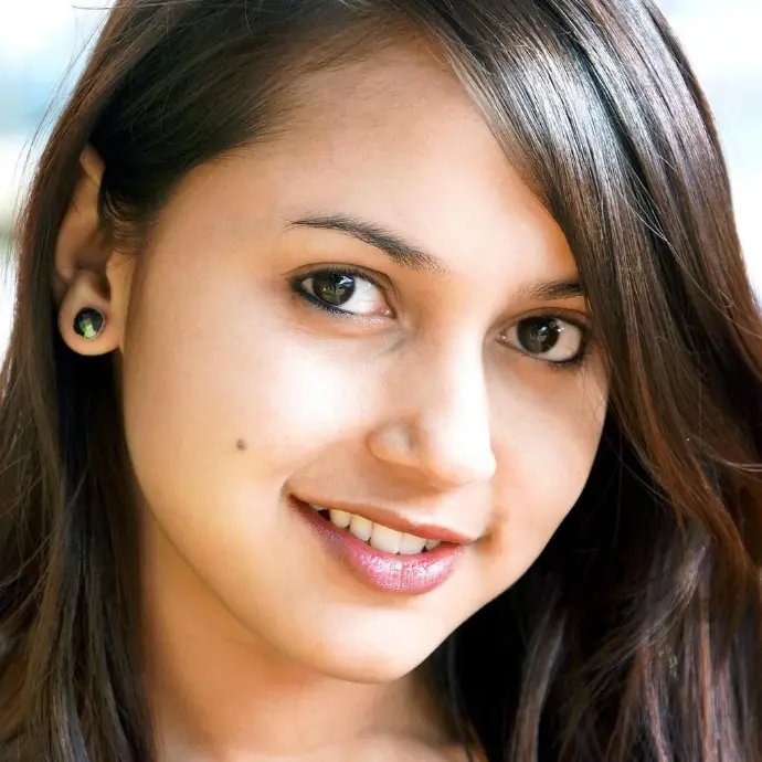 Portrait of Mughda smiling with long hair and natural look in a close-up shot